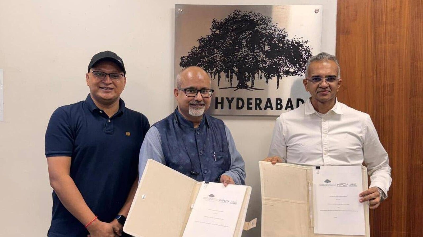 Cyber MANTHAN COO Mridul Chamoli, IIIT Hyderabad Director Prof Sandeep Shukla and NPCI MD and CEO Dilip Asbe holding MoU documents at IIIT Hyderabad