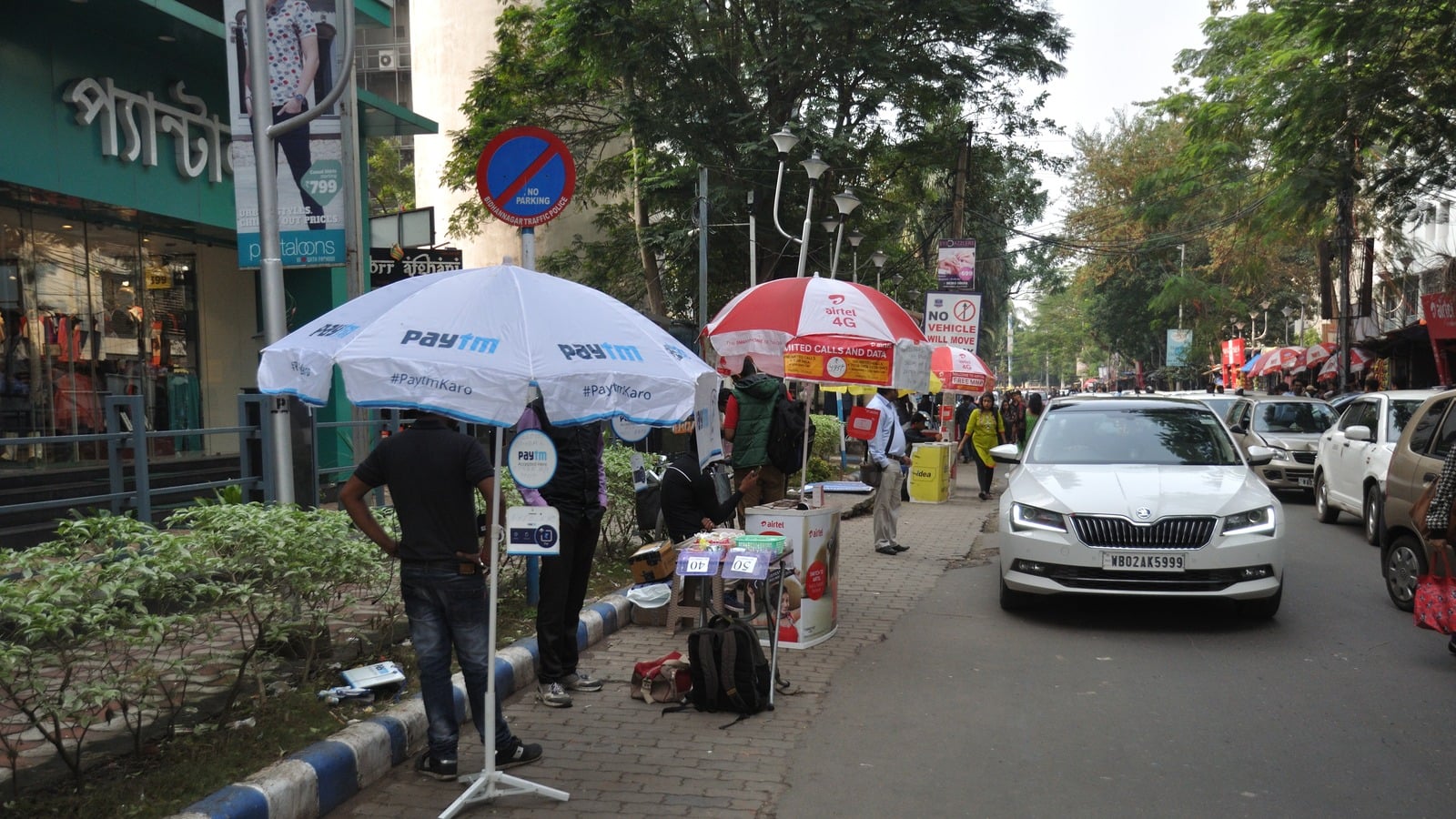 A Paytm-branded umbrella over a merchant onboarding stall on a street in Salt Lake City, Kolkata
