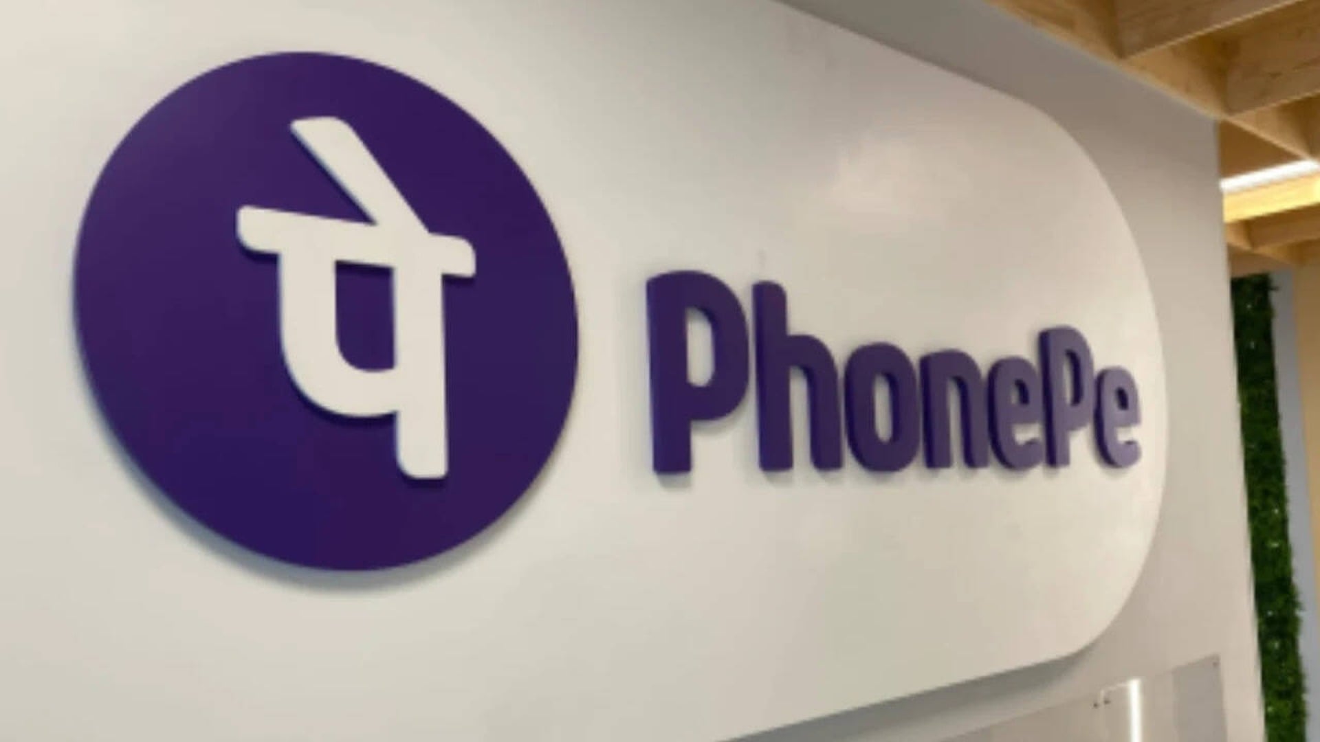 Purple PhonePe logo and wordmark on a white wall at a PhonePe office