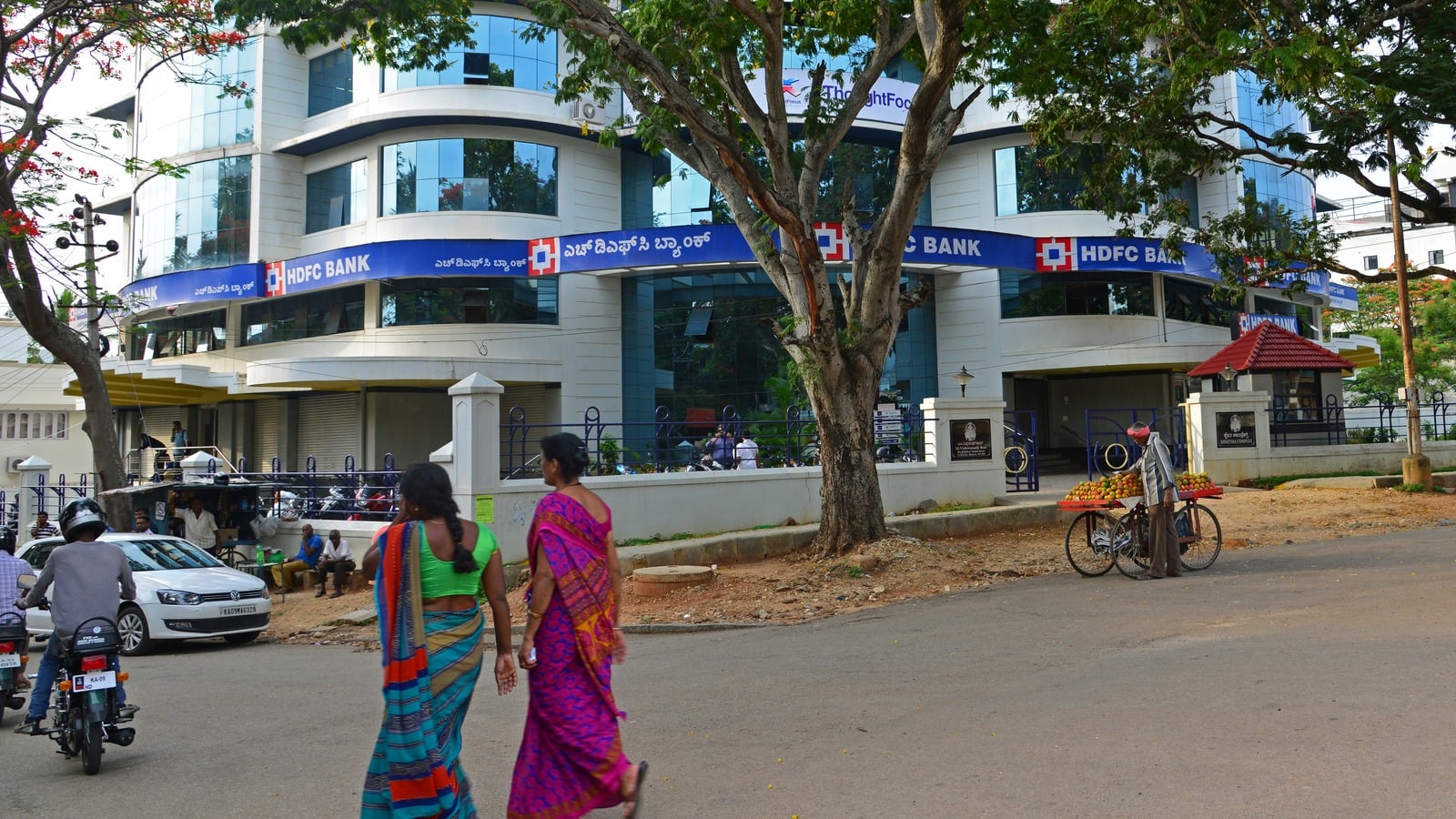 HDFC Bank branch in Mysuru with a street fruit vendor on a bicycle outside