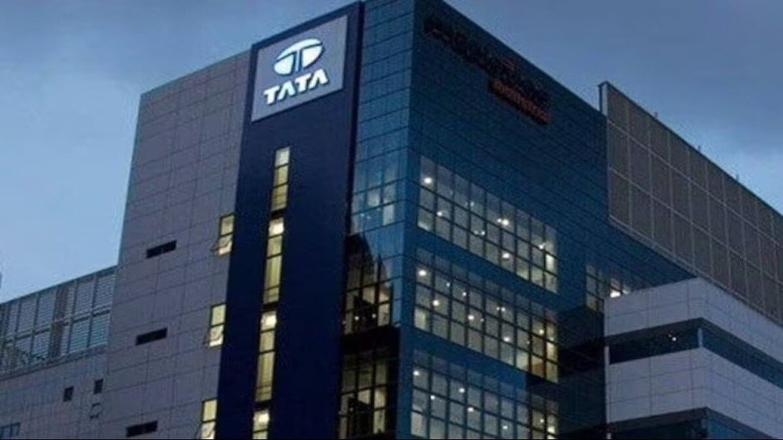 Tata building with illuminated Tata logo at dusk